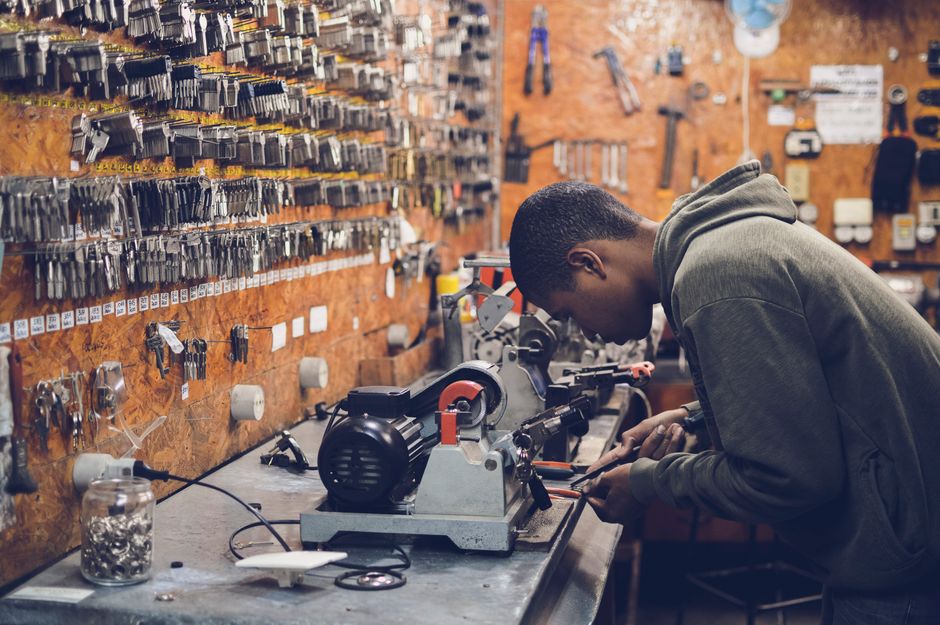 Keys cut on the shop machine in front of a wall of blanks